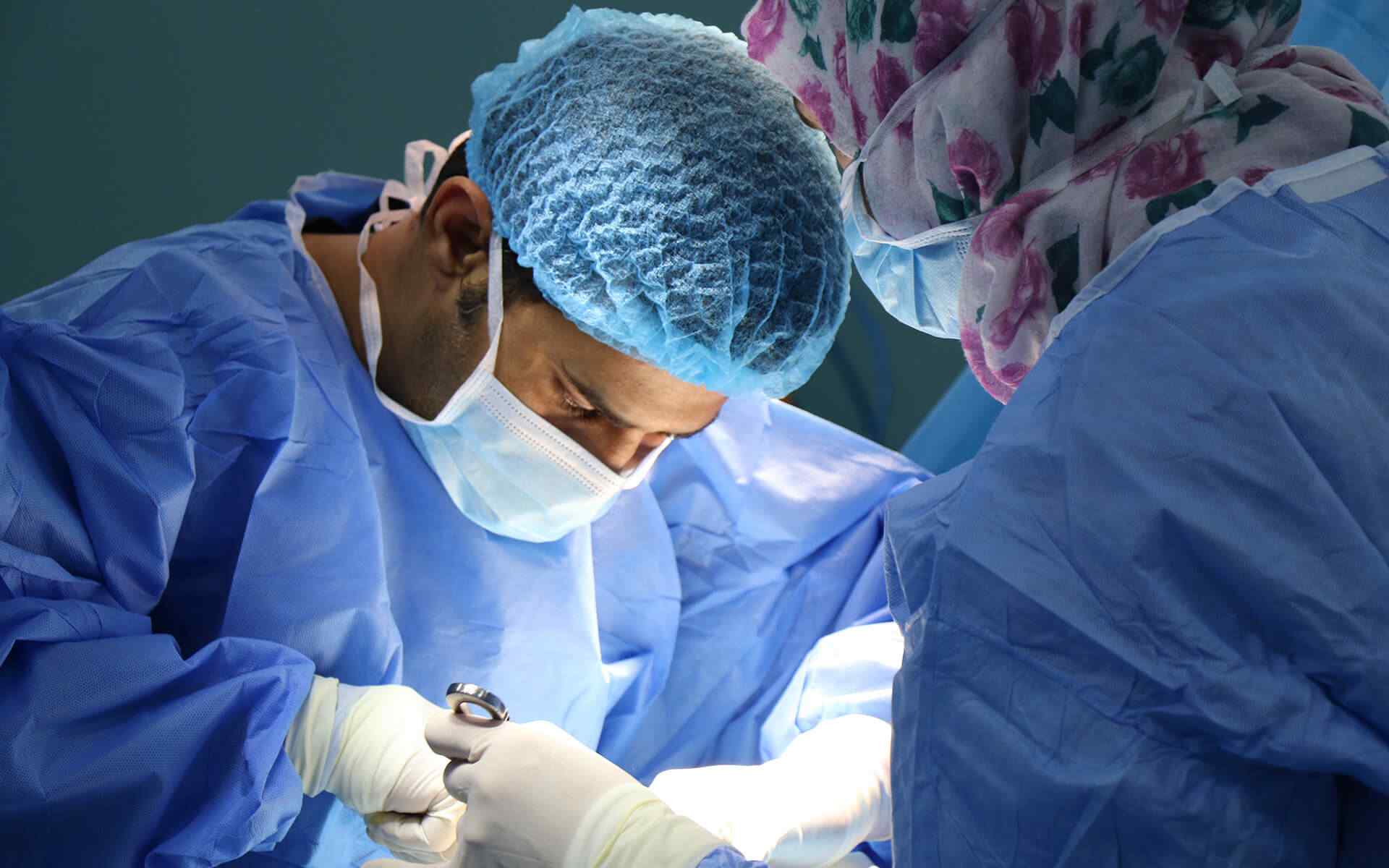 Surgical team performing minimally invasive keyhole surgery in a modern operating theatre