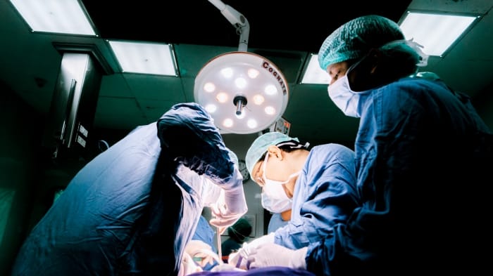 Surgical team performing minimally invasive laparoscopic surgery in an operating theatre